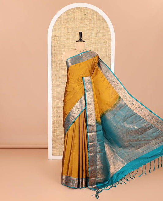 Gold plain luxury soft silk saree, contrast traditional temple zari border of elephant motifs, geometric zari pallu, and a contrast jacquard blouse