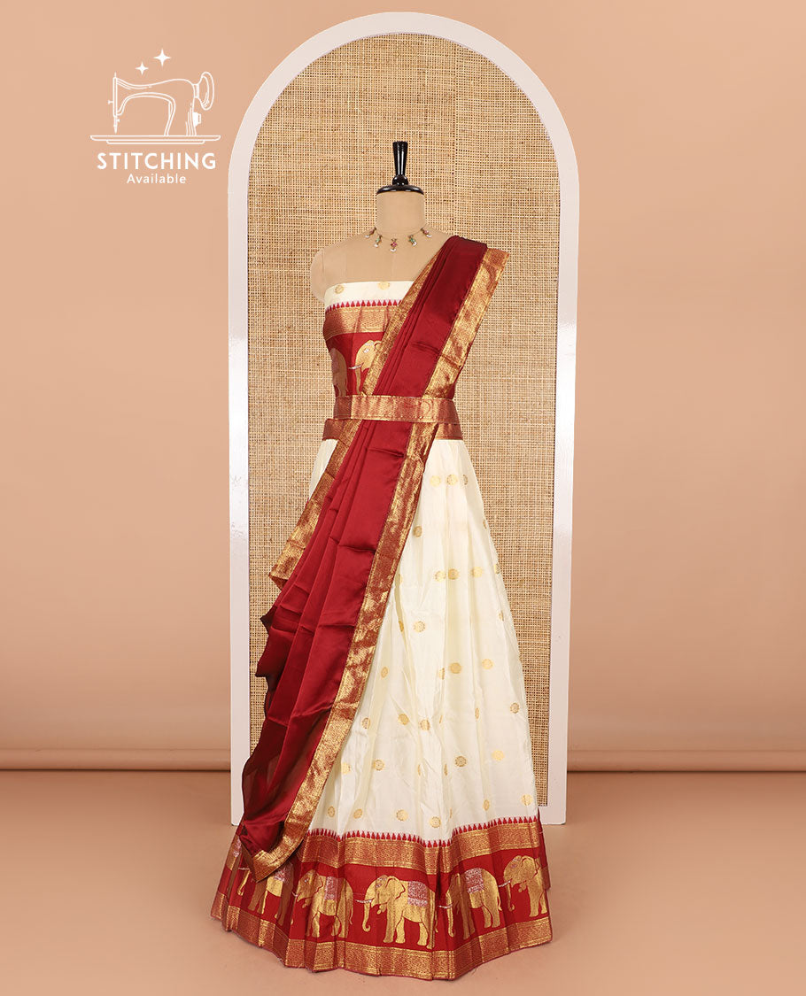 Cream-crimson half-saree, zari buttas with contrast traditional zari elephant motifs bordered skirt, matching blouse and a contrast zari border dhavani