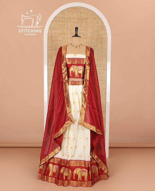 Cream-crimson half-saree, zari buttas with contrast traditional zari elephant motifs bordered skirt, matching blouse and a contrast zari border dhavani
