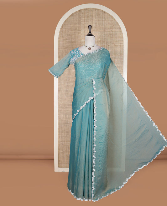 Blue plain designer saree, scallop embroidered border, and a matching elbow sleeve blouse of floral vine in micro-stones