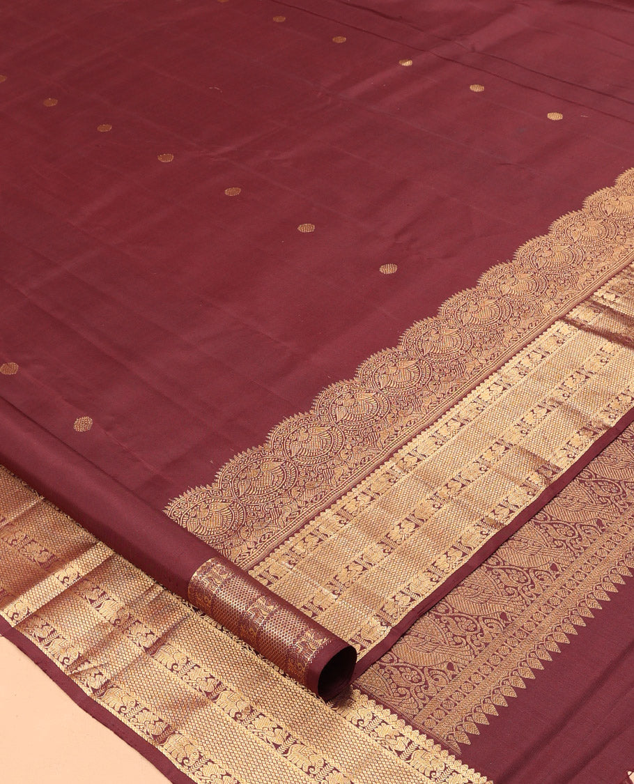 Brown Kanchipuram Silk Saree, Adorned with Zari Buttas, a Zari Border of Iruthalai Pakshi, Thilakam, Kathir, Mayil, Yaanai, and Mayil Kann Designs, Jaal Pallu, and a Matching Blouse