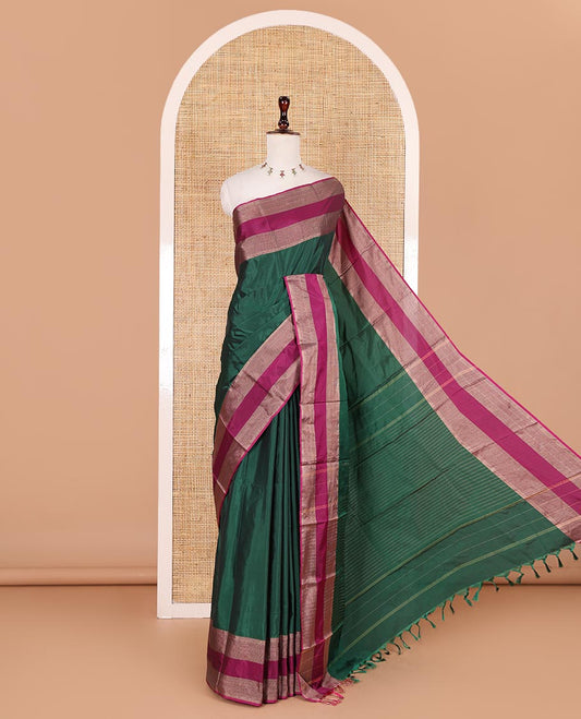 Dark green plain semi-soft silk saree, contrast zari striped border, striped pallu, and matching blouse