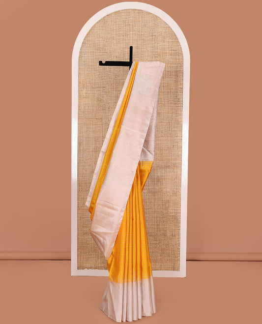 Yellow checked Kanchipuram silk saree, contrast border of zari buttas, and pallu of geometric patterns