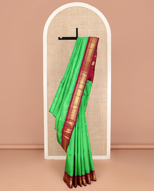 Green Kanchipuram Silk Saree, Embellished with Zari Buttas on Its Body, Complemented by a Contrast One-Sided Korvai Border of Rekku, Banaras, Muthu, and Mayil Kann Designs, Pallu Features Zari Designs, and Comes Without a Blouse