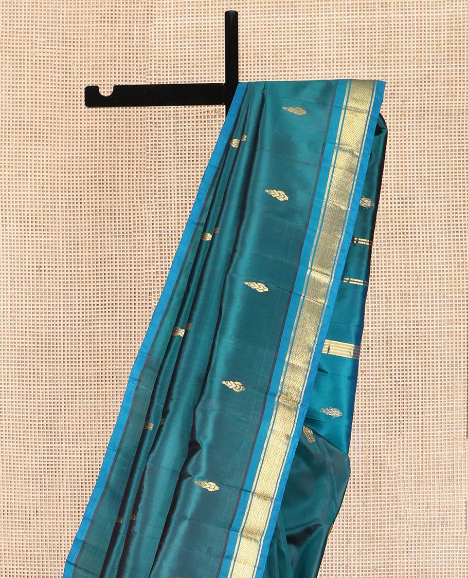 Blue Kanchipuram Silk Saree, Adorned with Zari Buttas on Its Body, Complemented by a Contrast One-Sided Border of Banaras, and Mayil Kann Designs, Pallu Steeped with Zari Designs, and Comes Without a Blouse