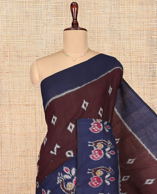 Brown Ikkat Cotton Saree, Decked Up with Ikkat Buttas All Over Its Body, Complemented by a Contrast Ikkat-Style Border of Peacock Buttas, Chevron Striped Pallu, and Paired with a Contrast Blouse
