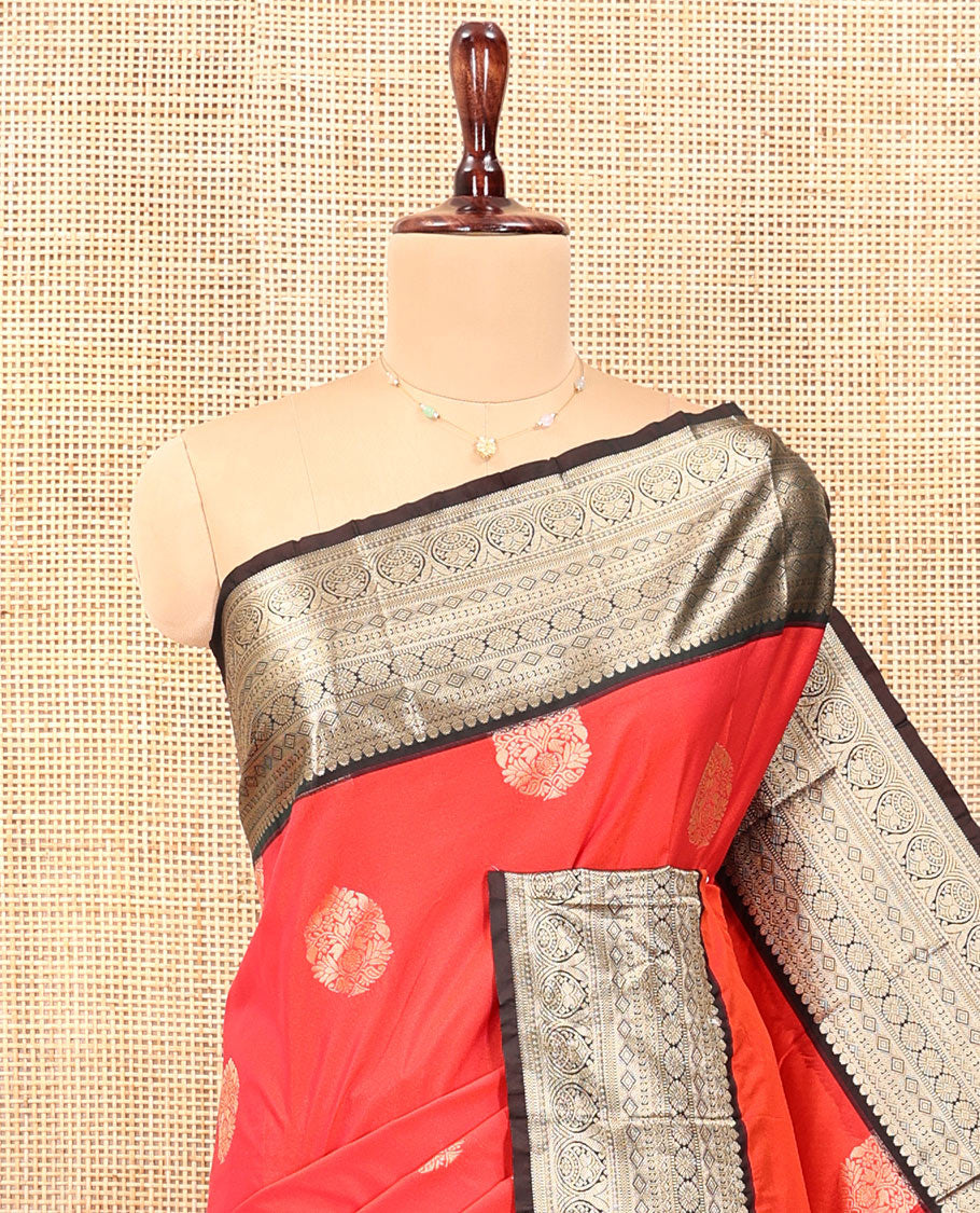 Reddish Orange Budget Silk Saree, Elevated with Floral Zari Buttas All Over Its Body, Complemented by Contrast Traditional Zari Designs Woven Big Border, Grandly Decked Up Pallu, and Paired with a Contrast Blouse