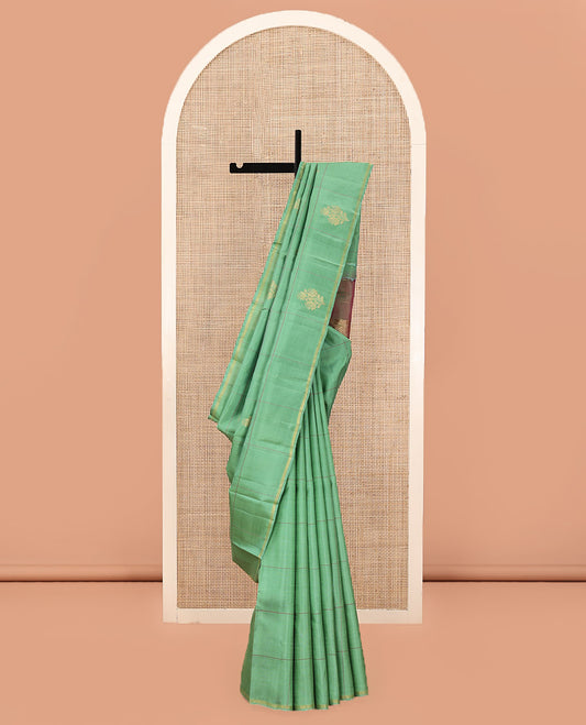 Green Kanchipuram Silk Saree, Beautifully Woven with Floral Butta Enclosed, Checked All Over Its Body, Subtle Zari Piping Border, Captivating Pallu of Intricate Designs, and Paired with a Contrast Blouse