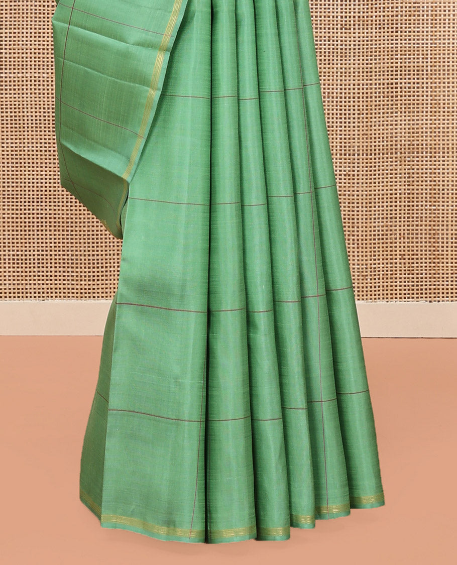 Green Kanchipuram Silk Saree, Beautifully Woven with Floral Butta Enclosed, Checked All Over Its Body, Subtle Zari Piping Border, Captivating Pallu of Intricate Designs, and Paired with a Contrast Blouse