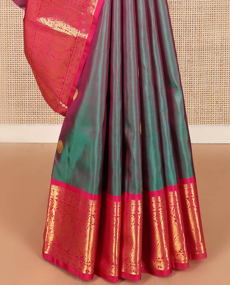 Green dual-tone chakram buttas Kanchipuram silk saree, contrast border of mayil chakram designs, and pallu of chakram buttas