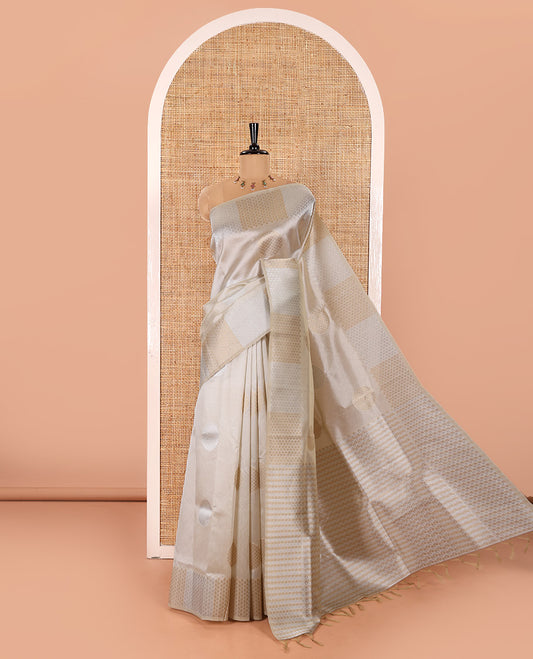Cream Semi Tussar Saree Adorned with Zari Circle Buttas, Gleaming Border Steeped with Zari Leaf Designs, Pallu Richly Woven with Leaf Designs in Zari, and Paired with a Matching Blouse