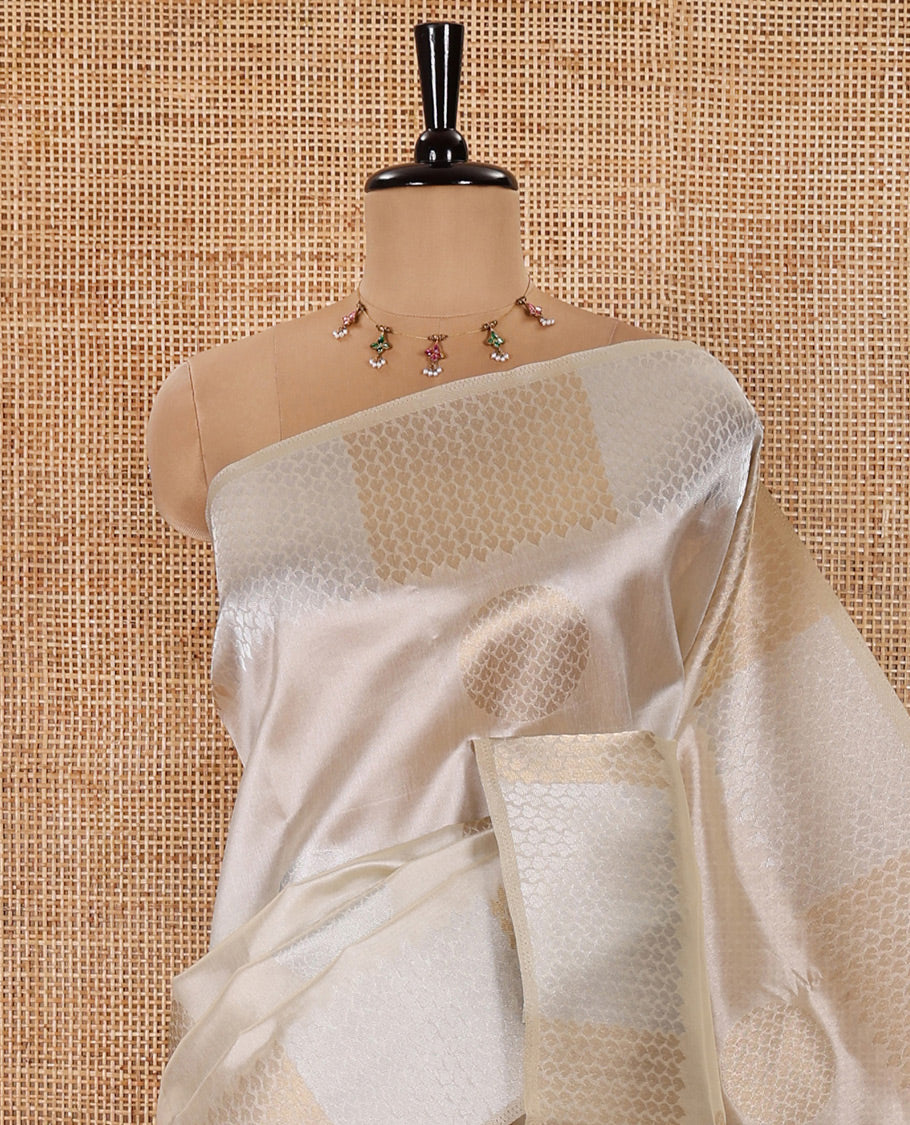 Cream Semi Tussar Saree Adorned with Zari Circle Buttas, Gleaming Border Steeped with Zari Leaf Designs, Pallu Richly Woven with Leaf Designs in Zari, and Paired with a Matching Blouse