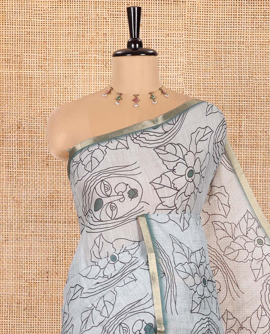 Light Green Linen Saree Creatively Printed with Girl Face and Floral Motifs All Over Its Body, Subtly Sparkled with Piping Zari Border, Pallu Mirrors the Same Body Print, and Paired with a Contrast Blouse