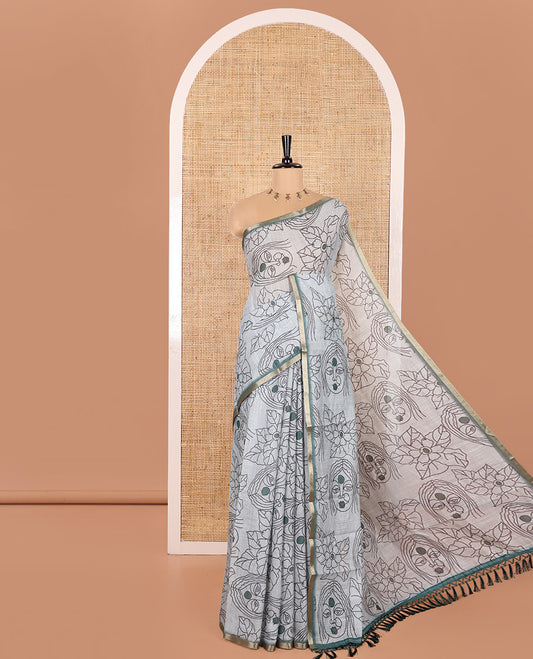 Light Green Linen Saree Creatively Printed with Girl Face and Floral Motifs All Over Its Body, Subtly Sparkled with Piping Zari Border, Pallu Mirrors the Same Body Print, and Paired with a Contrast Blouse