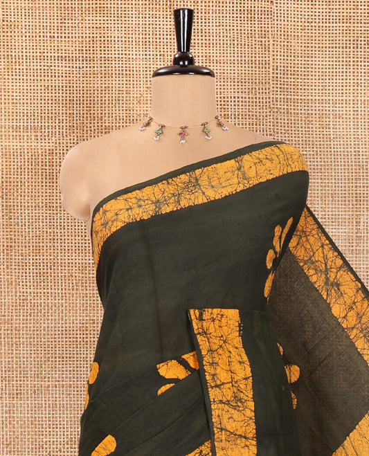 Green Mul Cotton Saree Prettified with Batik-Style Floral Motifs Printed All Over Its Body, Complemented by a Contrast Batik Printed Border, Pallu Mirrors the Same Batik Print, and Is Paired with a Matching Blouse