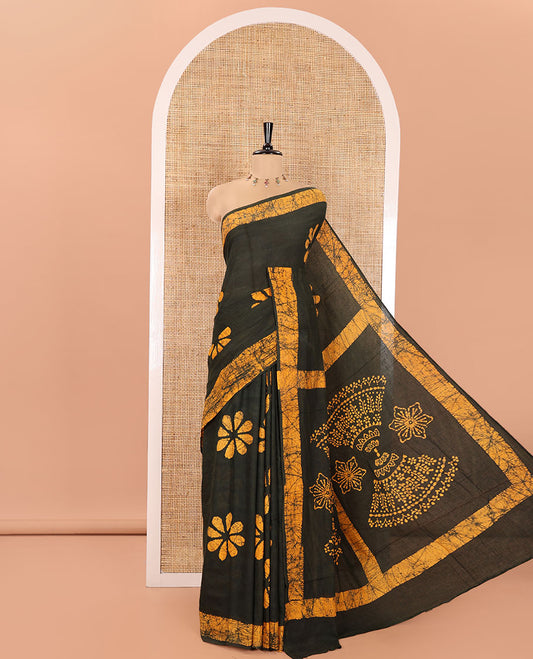 Green Mul Cotton Saree Prettified with Batik-Style Floral Motifs Printed All Over Its Body, Complemented by a Contrast Batik Printed Border, Pallu Mirrors the Same Batik Print, and Is Paired with a Matching Blouse