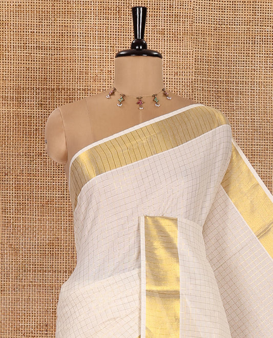 Cream Kerala Cotton Saree, Enthralled with Small-Sized Checks All Over Its Body, Subtle Bavanji Border, Scintillating Zari Design Pallu, and Paired with a Matching Blouse