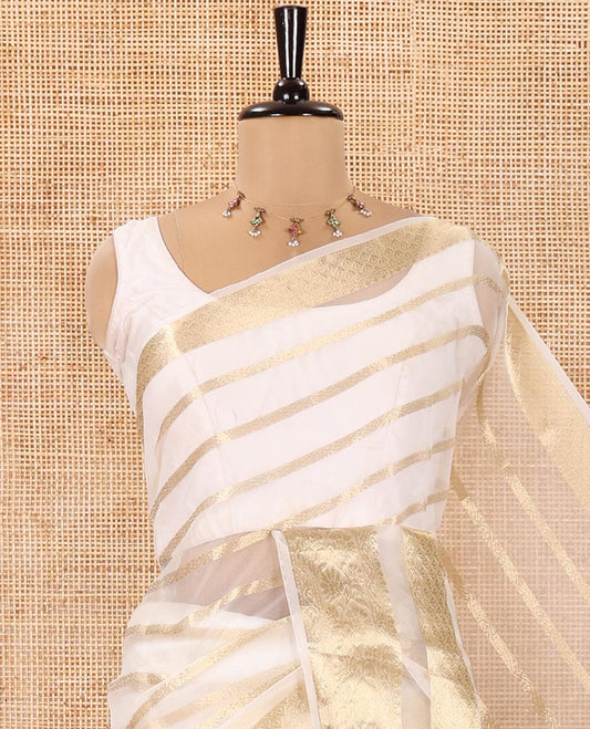 Cream Semi-Organza Saree, Gleamed Up with Zari Stripes All Over Its Body, Highlighted by a Traditional Zari Design Border, Gleaming Zari Striped Pallu, and Paired with a Matching Blouse