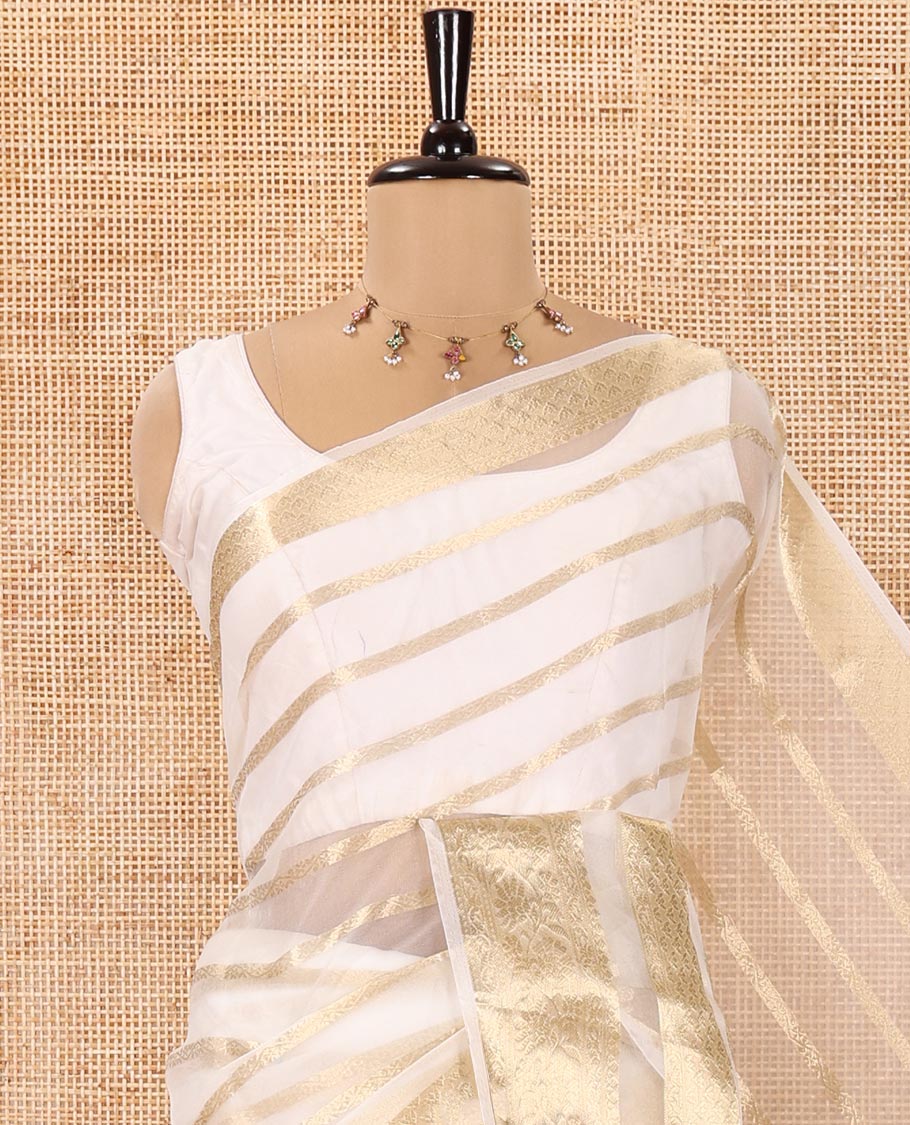 Cream Semi-Organza Saree, Gleamed Up with Zari Stripes All Over Its Body, Highlighted by a Traditional Zari Design Border, Gleaming Zari Striped Pallu, and Paired with a Matching Blouse