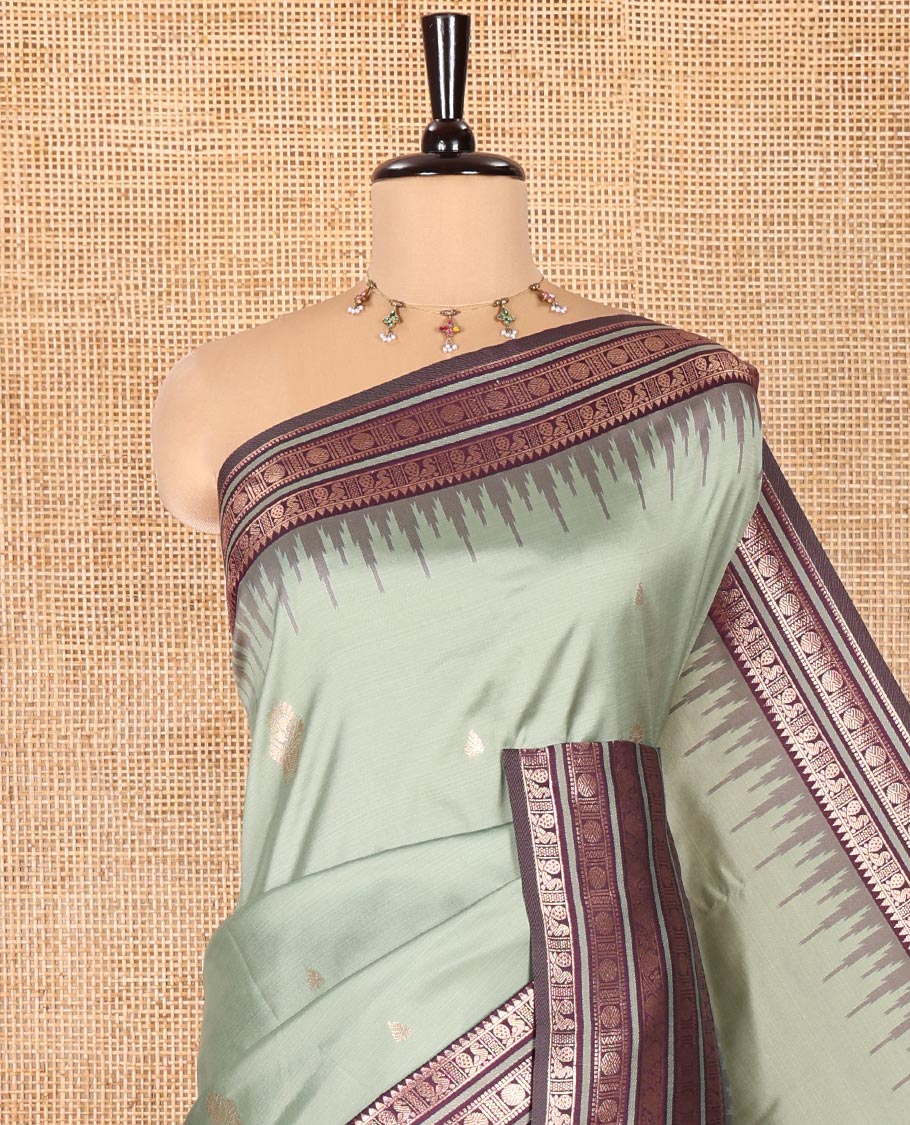 Pista Green Elite Soft Silk Saree, Enriched with Zari Buttas All Over Its Body, Complemented by Contrast Temple Traditional Zari Border of Peacock-Rudraksham Motifs, Intricately Zari Woven Pallu and Paired with a Contrast Blouse