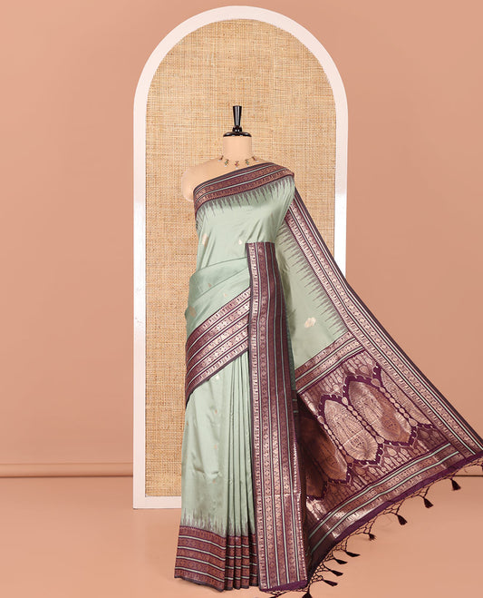 Pista Green Elite Soft Silk Saree, Enriched with Zari Buttas All Over Its Body, Complemented by Contrast Temple Traditional Zari Border of Peacock-Rudraksham Motifs, Intricately Zari Woven Pallu and Paired with a Contrast Blouse