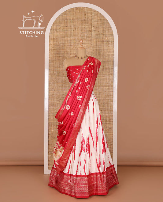 Cream and pink semi-tussar half-saree, shibori printed with contrast geometric patterned bordered skirt, bandhani printed blouse, and bandhani printed dhavani