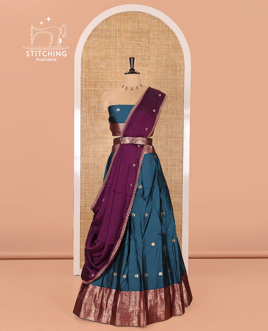 Blue and Purple Semi-Banarasi Half-Saree, Elevated with Zari Buttas on Its Skirt, Complemented by a Contrast Traditional Zari Designs Woven Border, Paired with a Matching Blouse, and a Satin Georgette Embroidered Scallop Dhavani