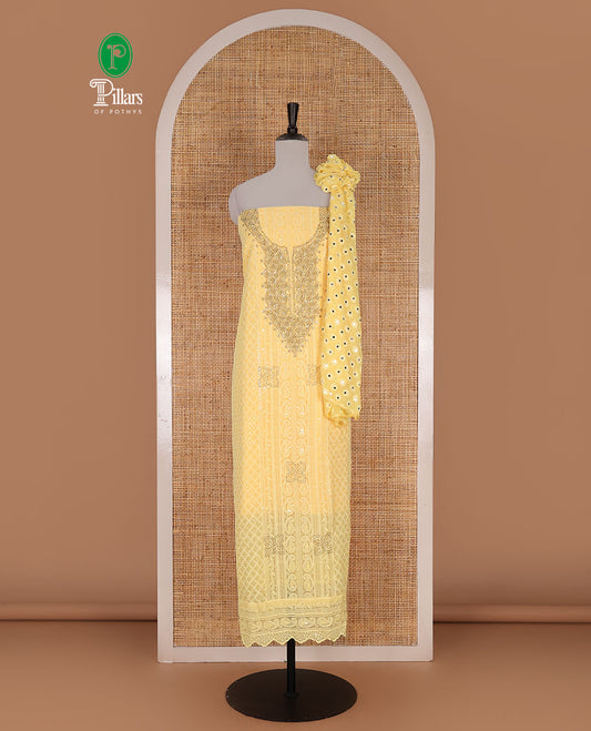 Yellow material churidar set, stone work with Schiffli style embroidered georgette top, American Crape bottom, and polka dotted printed mirror work dupatta