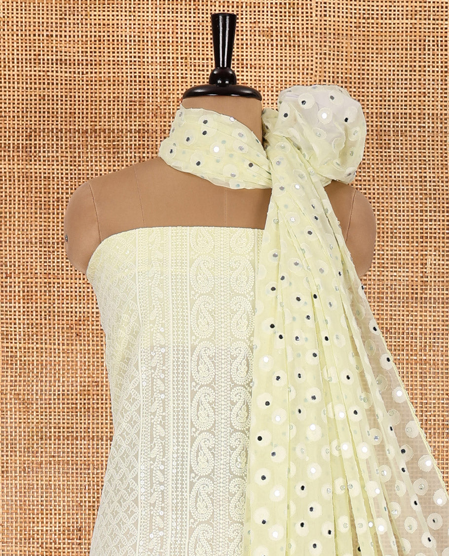 Lemon yellow material chudidar set, paisleys and jaal schiffli sequins embroidered mul georgette top, a matching bottom, and a mirror work dupatta