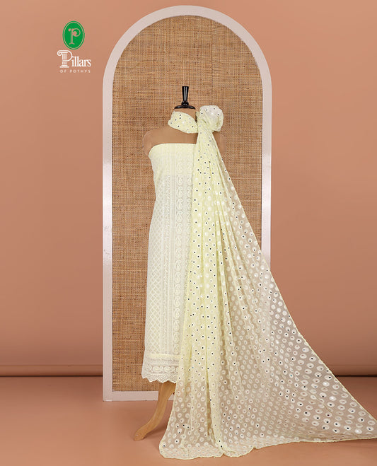 Lemon yellow material chudidar set, paisleys and jaal schiffli sequins embroidered mul georgette top, a matching bottom, and a mirror work dupatta