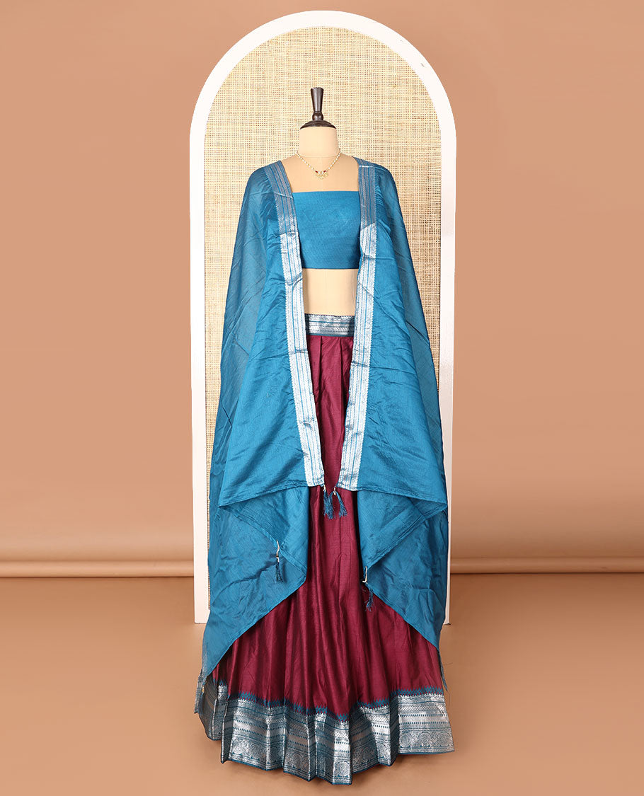 Maroon art-silk half-saree, plain with contrast temple traditional design bordered skirt, a contrast blouse, and a plain zari bordered dhavani