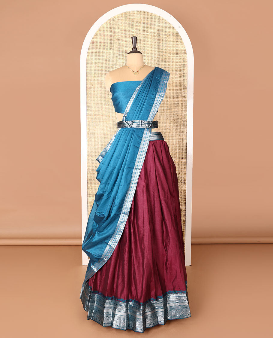 Maroon art-silk half-saree, plain with contrast temple traditional design bordered skirt, a contrast blouse, and a plain zari bordered dhavani