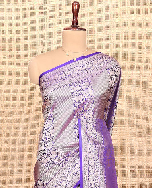 Violet Semi-Banaras Silk Saree, Gracefully Embellished with Animal-themed Jacquard Designs on Its Body, Highlighted by a Zari Border of Traditional Designs, Pallu Steeped with Stripes, and Paired with a Matching Blouse