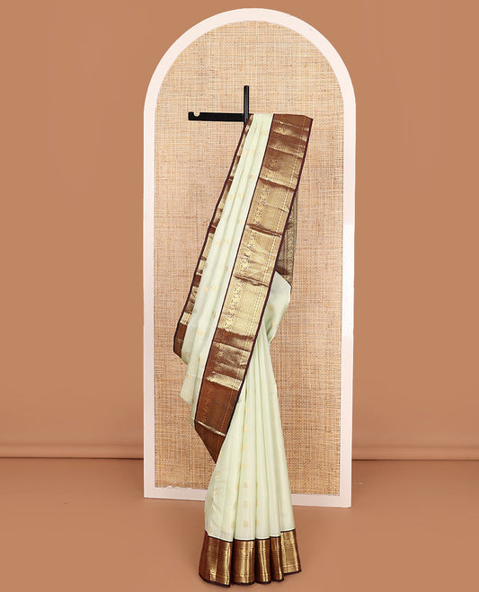 Enthralling Cream Vasundhara Lite-Silk Mix Saree Adorned with Zari Buttas, Complemented with a Contrast Border Featuring Muthu, Banaras, Neli, Manga, Mayil Kann, and Rudraksham Designs, Jaal Pallu, and a Contrast Blouse