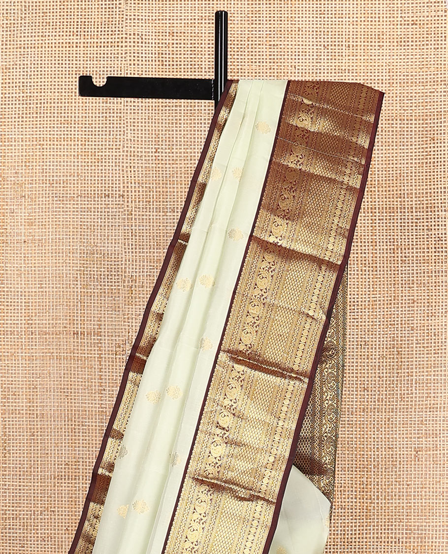 Enthralling Cream Vasundhara Lite-Silk Mix Saree Adorned with Zari Buttas, Complemented with a Contrast Border Featuring Muthu, Banaras, Neli, Manga, Mayil Kann, and Rudraksham Designs, Jaal Pallu, and a Contrast Blouse