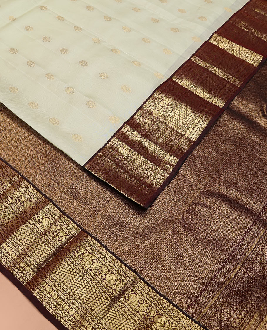 Enthralling Cream Vasundhara Lite-Silk Mix Saree Adorned with Zari Buttas, Complemented with a Contrast Border Featuring Muthu, Banaras, Neli, Manga, Mayil Kann, and Rudraksham Designs, Jaal Pallu, and a Contrast Blouse