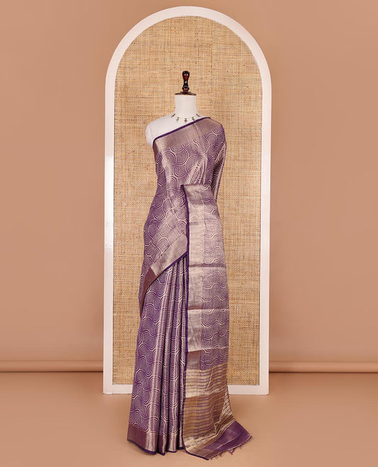 Purple scallop design tissue saree, zari striped border, striped pallu, and gleaming matching blouse