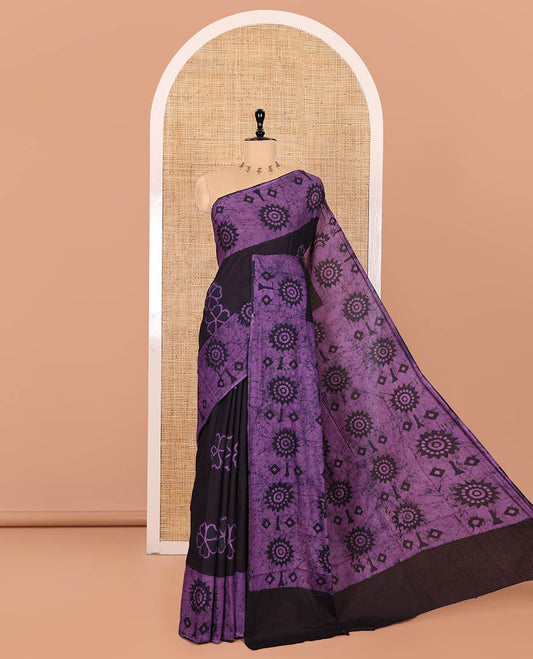 Brown Mul Cotton Saree Adorned with Batik-Style Floral Motifs Print, Featuring a Batik-Style Geometric Printed Border, Pallu Mirrors the Same Print, and Paired with a Matching Blouse