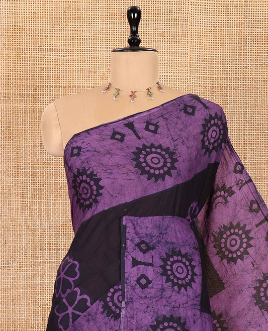 Brown Mul Cotton Saree Adorned with Batik-Style Floral Motifs Print, Featuring a Batik-Style Geometric Printed Border, Pallu Mirrors the Same Print, and Paired with a Matching Blouse