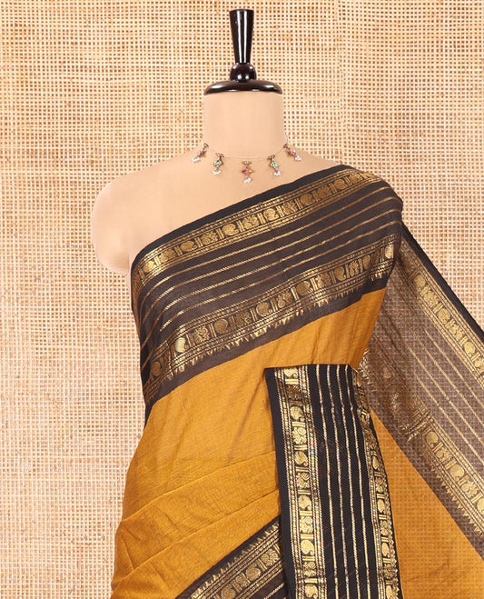 Mustard Plain Chettinad Cotton Saree, Complemented by a Contrast Traditional Zari Border of Paisley and Peacock Designs, Subtly Striped Pallu, and Paired with a Matching Blouse