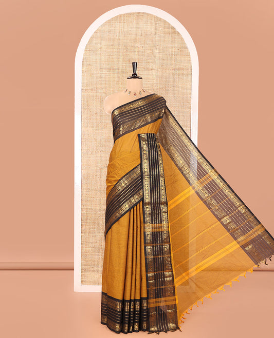 Mustard Plain Chettinad Cotton Saree, Complemented by a Contrast Traditional Zari Border of Paisley and Peacock Designs, Subtly Striped Pallu, and Paired with a Matching Blouse