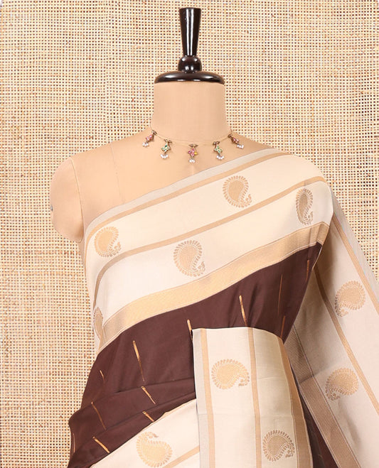 Brown and Cream Kanchi Silk Saree, Bedecked with Zari Buttas All Over Its Body, Complemented by a Contrast Border of Paisleys, Zari-Striped Pallu, and Paired with a Contrast Jacquard Blouse