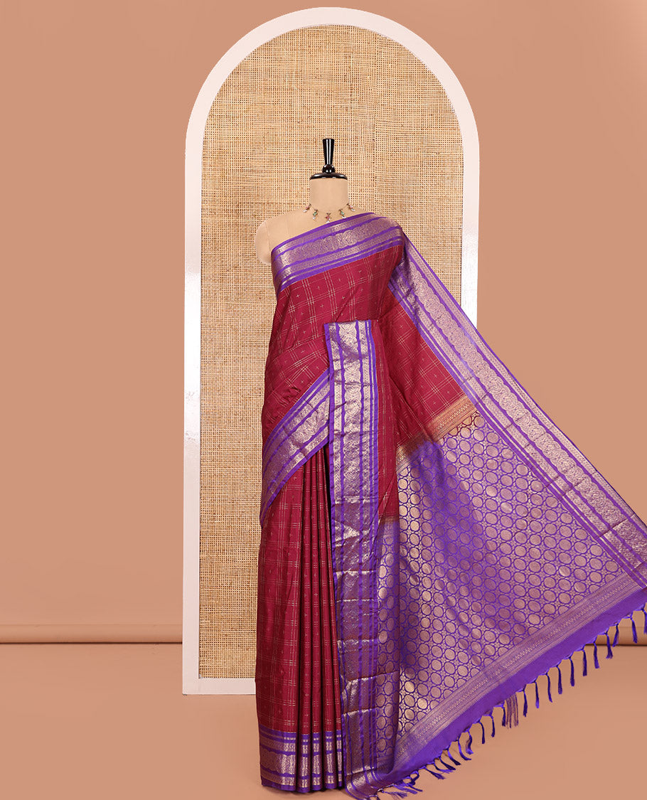 Maroon Kanchipuram Budget Silk Saree, Ornamented with Plus-Sized Butta Enclosed Checks All Over Its Body, Complemented by a Contrast Traditional Zari Border of Round Peacock Designs, Pallu Steeped with Circle Motifs, and Paired with a Contrast Blouse