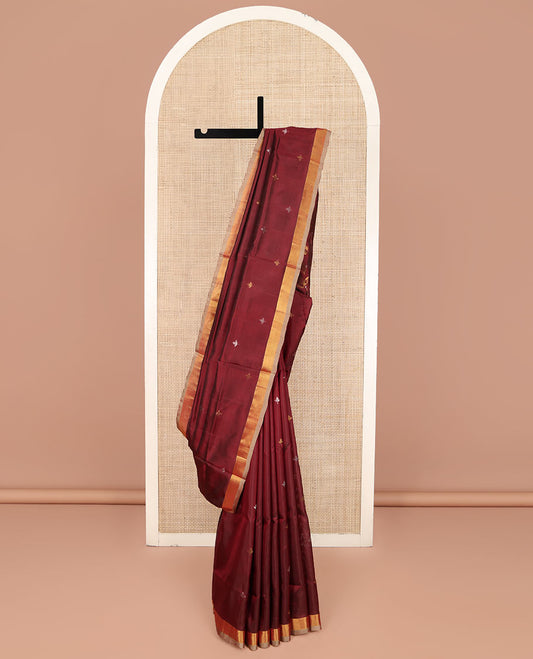 Maroon Uppada Silk Saree, Adorned with Zari Buttas All Over Its Body, Complemented by a Contrast Plain Border, Pallu Features Floral Jaal Designs, and Paired with a Matching Blouse