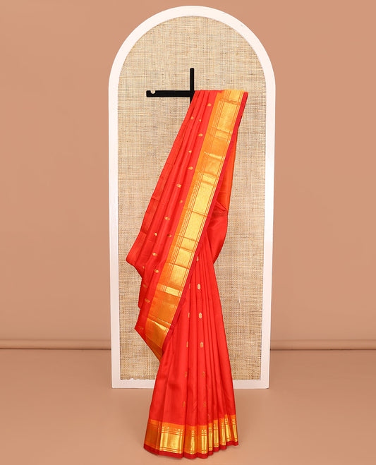 Orange Kanchipuram Silk Saree, Bedecked with Zari Buttas All Over Its Body, Complemented by a Contrast One-Sided Border of Panner Sombu, Banaras, and Mayil Kann Designs, Pallu of Zari Designs, and Comes Without a Blouse