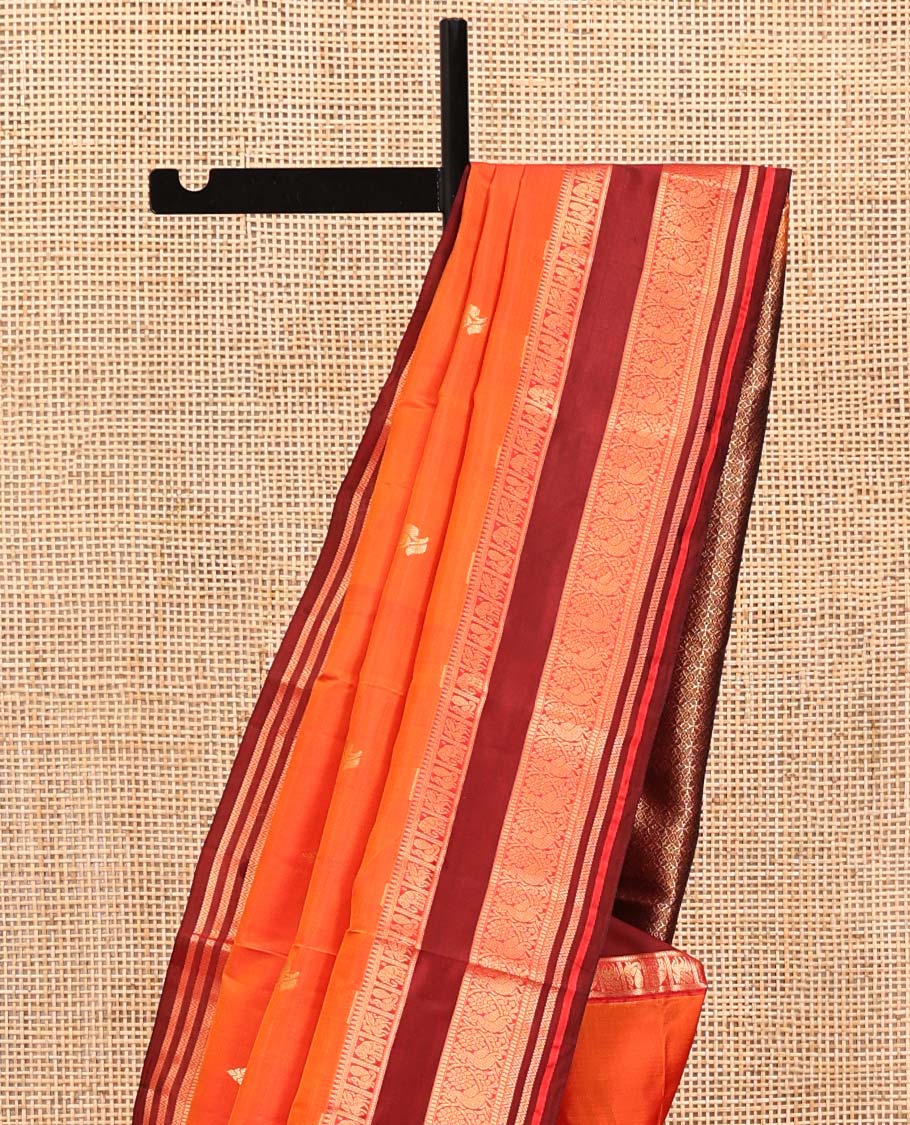 Orange Vasundhara Lite Silk Mix Saree, Accentuated With Zari Buttas All Over Its Body, Complemented by Captivating Contrast Border of Rekku, Mayil, Kuthirai, Yaanai, and Neli Designs, Grand Pallu, and Paired with a Contrast Blouse
