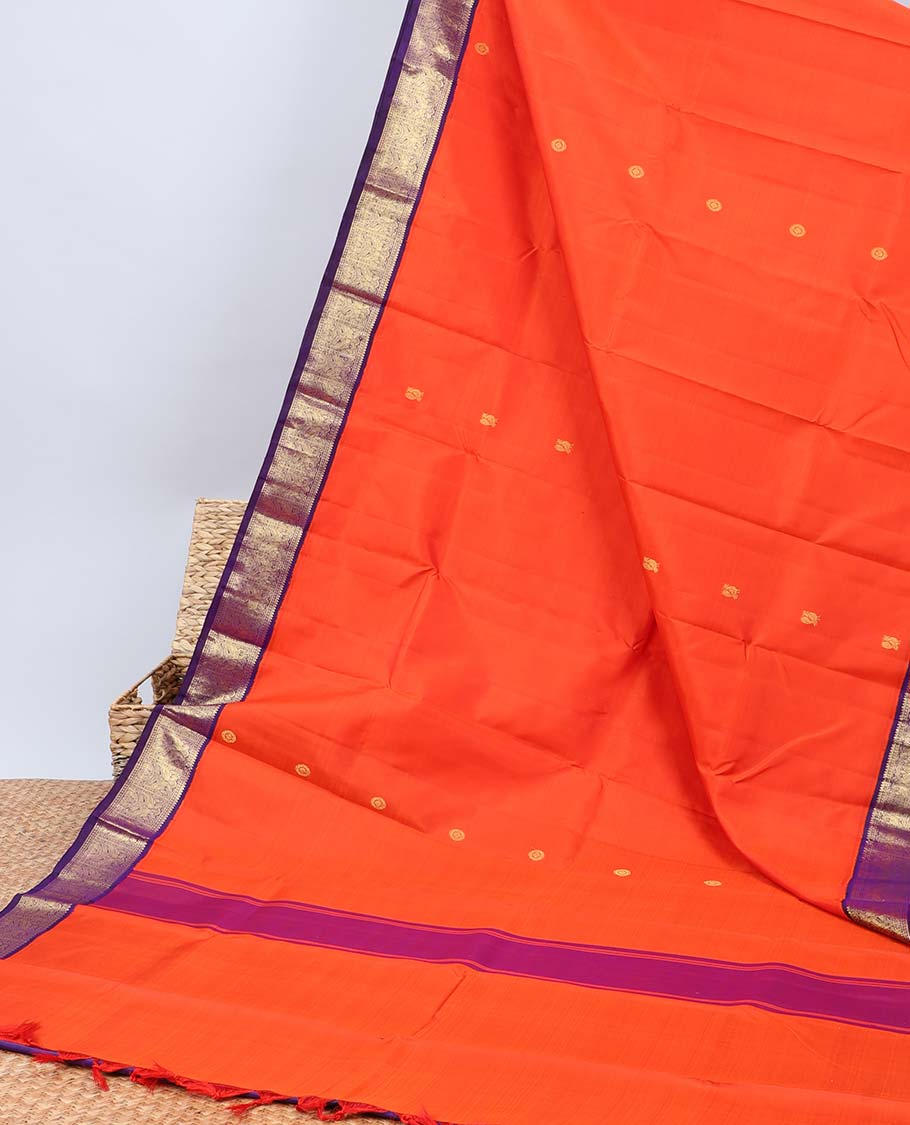 Orange kancheepuram silk saree with mayil & chakram buttas,contrast korvai border of rekku,muthu,lavangam,mayil & yaanai
