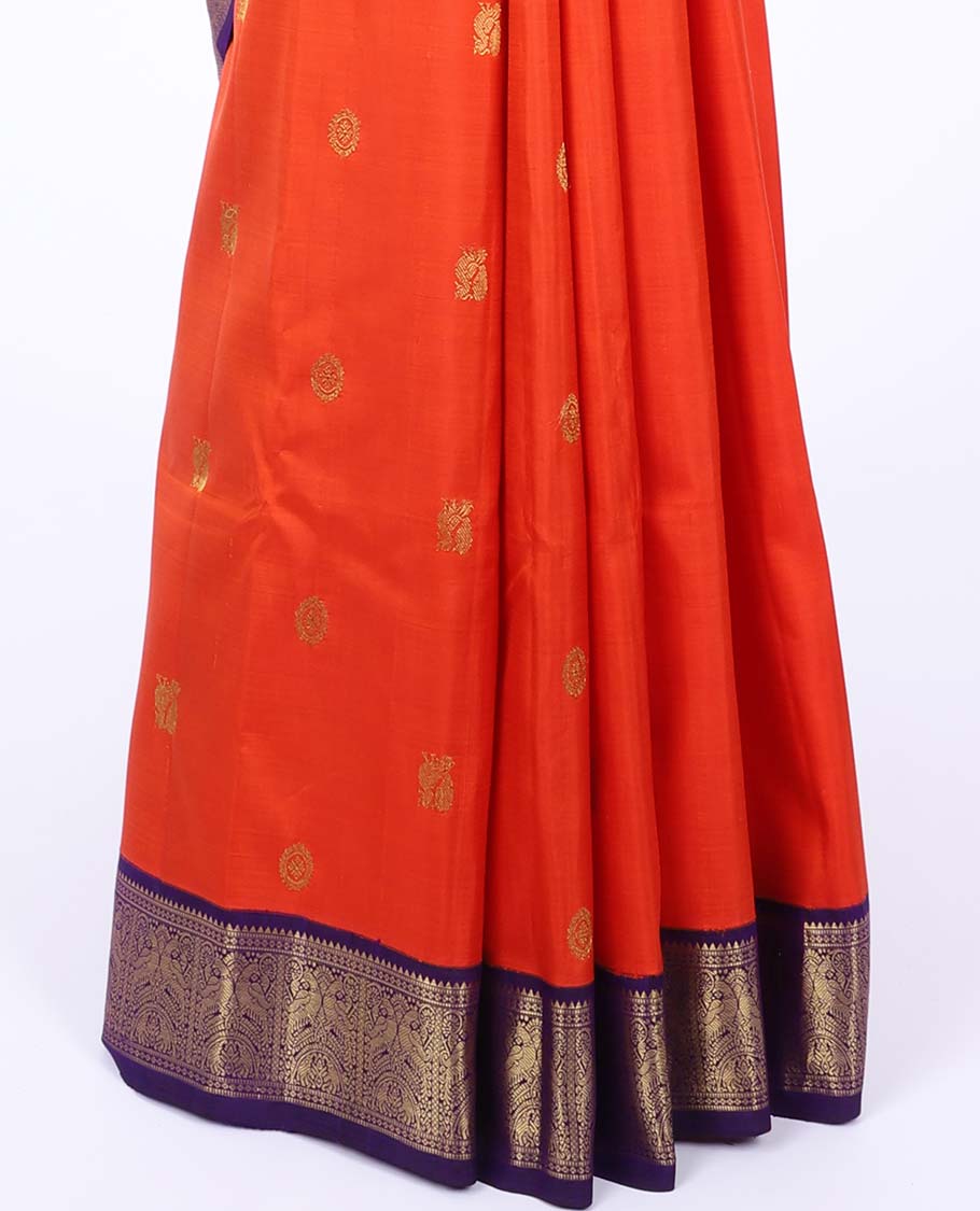 Orange kancheepuram silk saree with mayil & chakram buttas,contrast korvai border of rekku,muthu,lavangam,mayil & yaanai