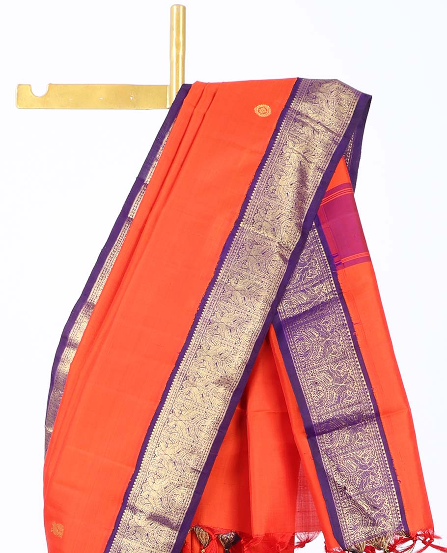 Orange kancheepuram silk saree with mayil & chakram buttas,contrast korvai border of rekku,muthu,lavangam,mayil & yaanai