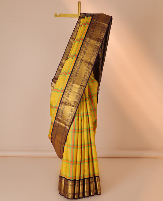 Yellow checked design silk saree, contrast korvai border of thilakam mokku,muthu,poun,mayil & yaanai
